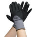 A pair of hands wearing Cordova Conquest black and grey gloves.