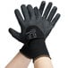 A close-up of a pair of black Cordova warehouse gloves with a black palm coating and nitrile dots.