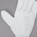 A white Cordova warehouse glove with white polyurethane coating on the palm.