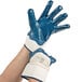 A pair of hands wearing blue Cordova Smooth Nitrile gloves with white jersey lining