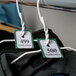 A pair of white coat room check tickets on clothes hangers.
