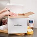 A person putting meat in a Nordic insulated shipping box on a table.