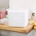 A Nordic insulated white polystyrene cooler on a table with food inside.