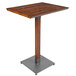 A Lancaster Table & Seating live edge bar height table with a metal base.