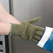 A person wearing a green Cordova Ragg Wool work glove.