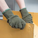 A pair of hands wearing Cordova green ragg wool and acrylic work gloves holding a box.