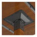 The corner of a Lancaster Table & Seating wood and metal table top with a metal bracket.