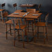 A Lancaster Table & Seating bar height table with chairs and napkins.