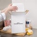 A person putting food into a Nordic insulated shipping box with a polystyrene cooler.