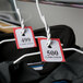Red Choice paper coat room check tickets on clothes hangers.