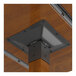 A metal and wood table leg with a metal corner bracket on a wood surface.