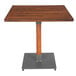 A Lancaster Table & Seating square wooden table with a metal base.