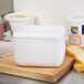 A Nordic TL-864F white foam container on a cutting board next to cheese and other food items.