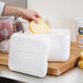 A person putting cheese into a Nordic insulated white foam container.