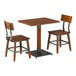 A rustic walnut finish solid wood table with a live edge and two matching industrial-style chairs.