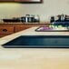 Two Matfer Bourgeat blue carbon steel sheet pans on a wooden countertop.