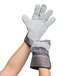 A pair of hands wearing Cordova striped canvas work gloves with leather palms.