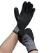 A pair of hands wearing gray Cordova warehouse gloves with black foam nitrile coating and nitrile dots.