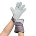 A pair of hands wearing Cordova striped canvas and leather work gloves.