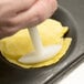 A person using a Matfer Bourgeat double-sided molding stamp to press dough.