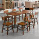 A Lancaster Table & Seating rustic wood table with chairs in a dining area.