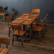 A Lancaster Table & Seating wooden table and chairs in a restaurant dining area.