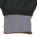 A close-up of a gray Cordova Conquest Xtreme glove with black and brown coating and nitrile dots.