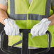 A man wearing Cordova gray leather driver's gloves holding a black and white tool.