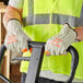 A person wearing Cordova standard grain leather driver's gloves with Hi-Vis orange fingertips.