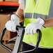 A person wearing Cordova gray leather driver's gloves and a vest holding a forklift.