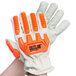 A close up of a hand wearing a Cordova Outlaw leather glove with orange and white accents.