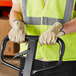 A man wearing Cordova pigskin leather gloves and a safety vest holding a forklift.