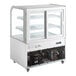 An Avantco white refrigerated bakery display case with curved glass doors.