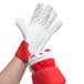 A person wearing red Cordova canvas work gloves with white rubber cuffs.