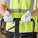 A man in a safety vest wearing Cordova Premium Grain Goatskin Driver's Gloves holding a forklift.