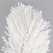 A white flower with a stem on a gray surface.