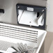 A white perforated drain box with silverware in it.