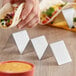 A person holding a taco in a stainless steel taco holder.