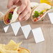 A person using a stainless steel Choice taco holder to hold tacos.