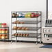 A Regency black epoxy mobile merchandising rack with shelves of food on it.