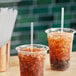 Two plastic cups with brown liquid and Choice jumbo straws.