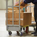 A man using a Winholt heavy duty utility cart to move a cardboard box.