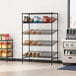 A black metal Regency stationary merchandising rack with food items on the shelves.