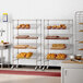 A Regency chrome wire rack of baking pans in a kitchen.