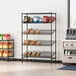 A black Regency wire shelving rack with food and snacks on the shelves.