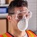 A pair of clear Cordova general purpose safety goggles worn by a person.