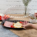A person placing a plastic oval dome lid on a plastic tray.