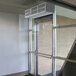 A Curtron low profile air curtain over a glass door in a school kitchen.