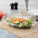 A salad in a Fineline clear plastic oval bowl.