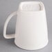 A Hall China bright white mug with a handle.